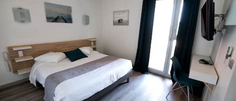 Un dormitorio moderno con una cama, un escritorio y un televisor.