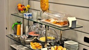 Un bufé con diversos alimentos, como frutas, pan y productos lácteos.