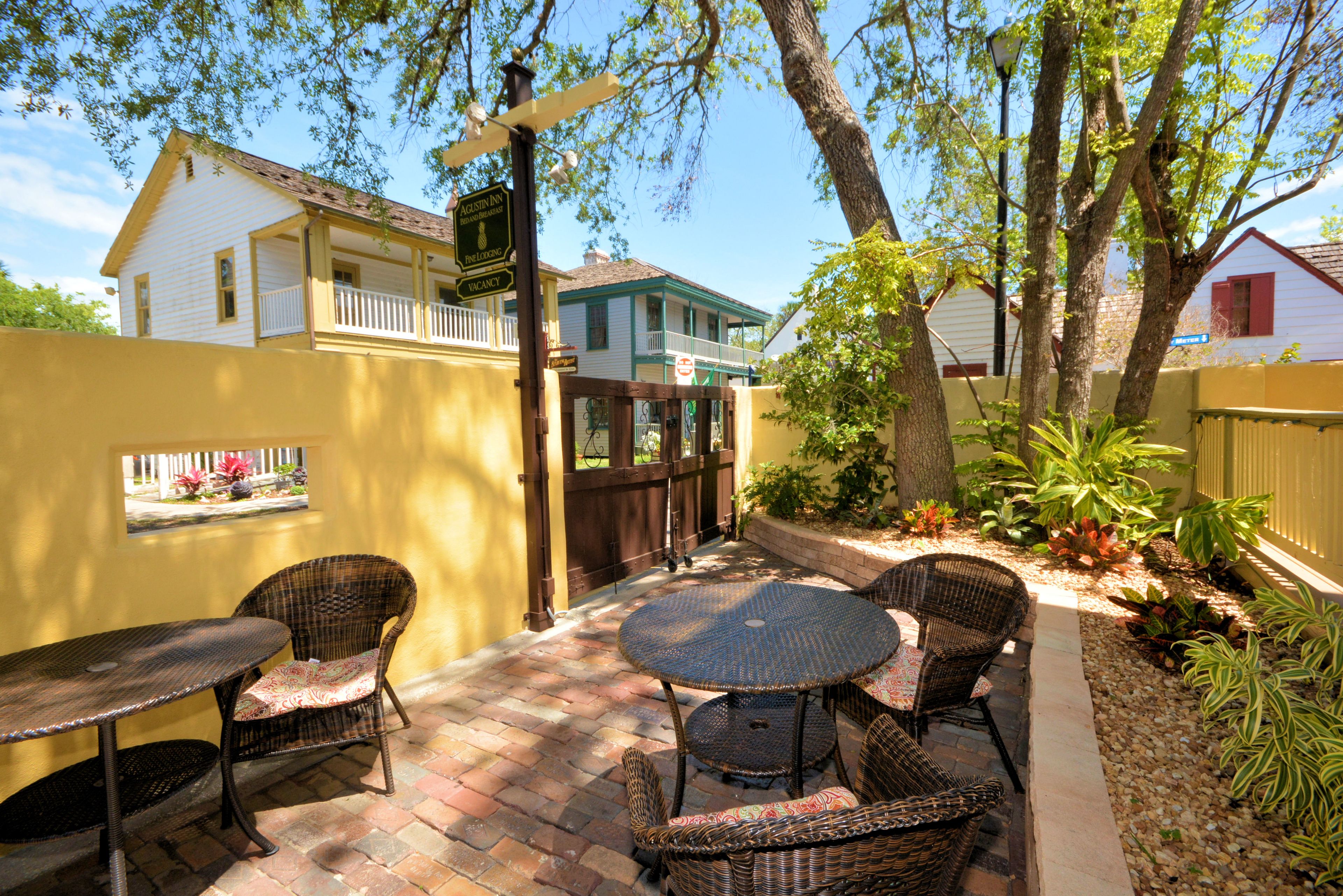 A patio with wicker furniture and a brick floor.