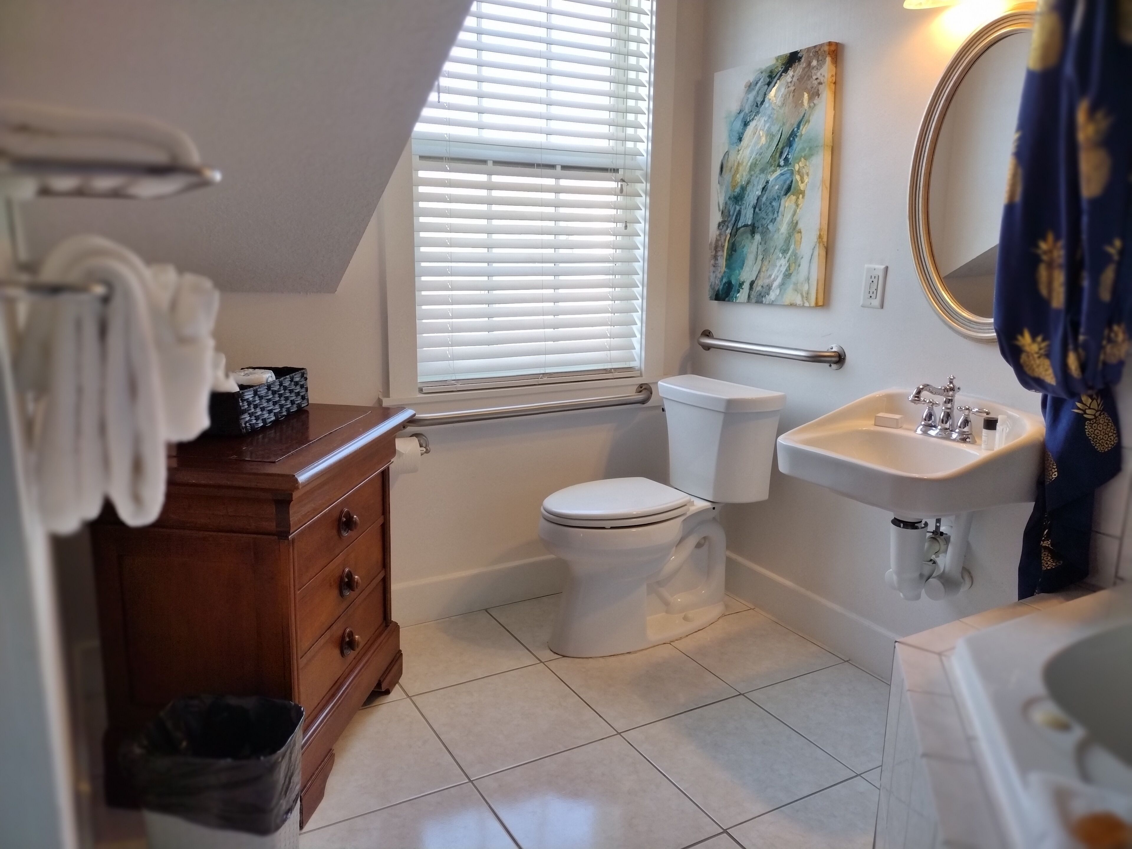 Une salle de bain équipée de toilettes, d’un lavabo et d’un meuble-lavabo en bois.