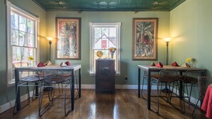 A dining area with wooden tables and chairs, a globe on a stand, and framed botanical paintings on the walls. - Agustin Inn (St. Augustine)