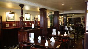 Un restaurante con muebles de madera, suelo a cuadros y cuadros en la pared.