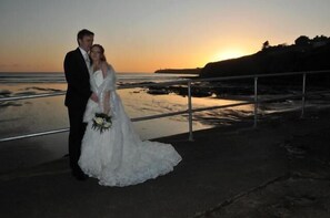 A couple standing on a balcony with a sunset view. - O'Sheas Hotel Tramore (Tramore)