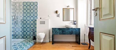 A bathroom with a shower, toilet, sink, and mirror.