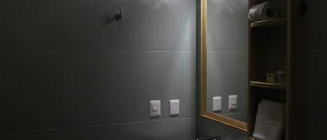 A bathroom with a sink, mirror, and towel rack.