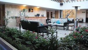 Un espacio interior amplio con techo alto, disposición de asientos y mostrador de recepción.