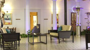 A lobby with wicker furniture, a coffee table, and a decorative lamp.