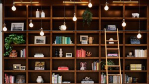 A library with bookshelves, a ladder, and hanging light fixtures. - Metcalfe Hotel Ottawa by Gray Collection (Ottawa)