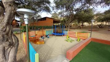 Children can play safely in this outdoor play area with a swing set and climbing frame.