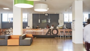 Una recepción moderna con un gran letrero de '40', asientos y una zona de bar.