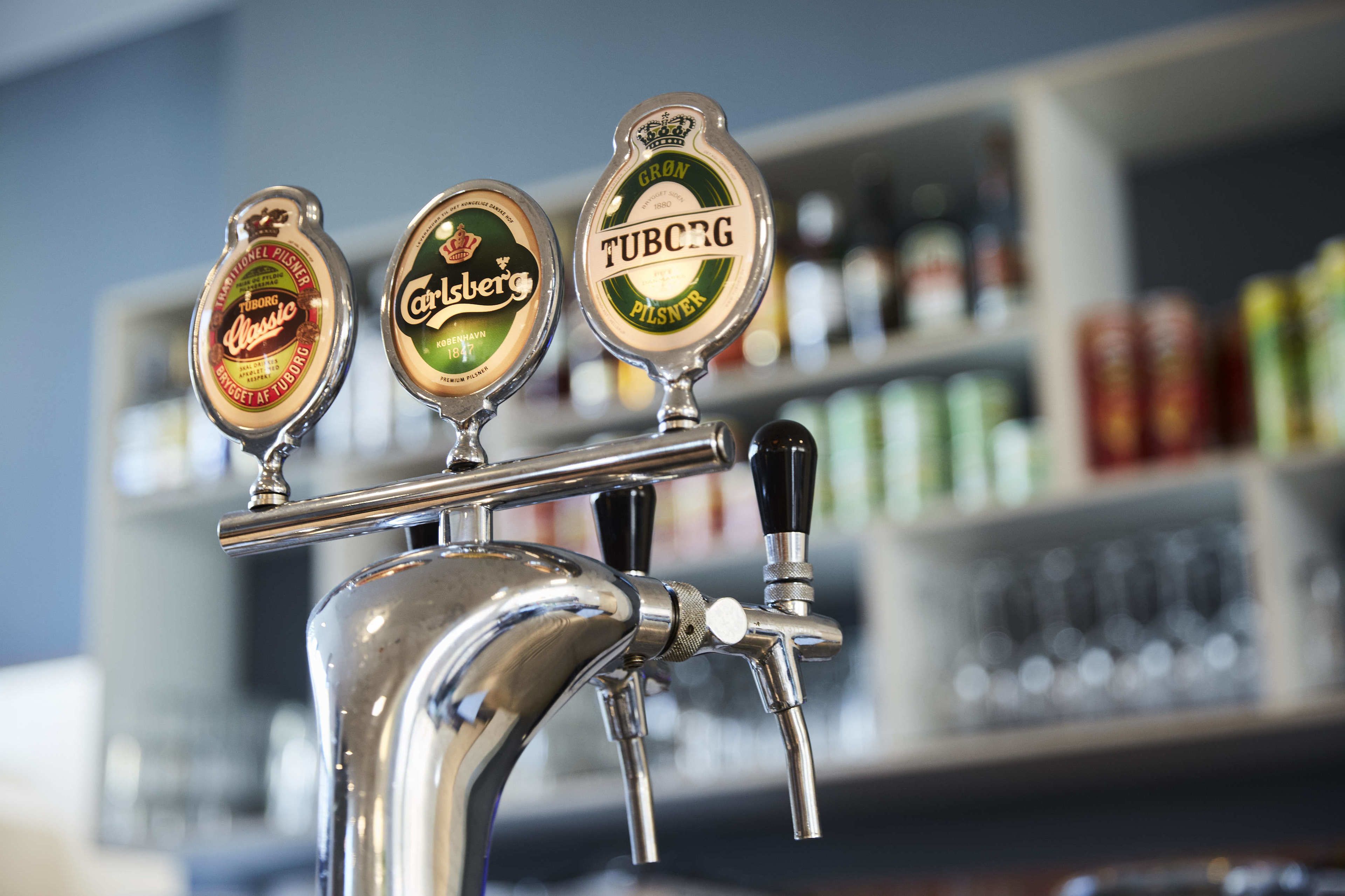 Een kraan met drie biervat etiketten: Carlsberg Classic, Carlsberg en Tuborg Pilsner.