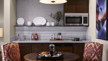 Una cocina moderna con un microondas Bosch, una cafetera y una mesa de comedor con sillas.