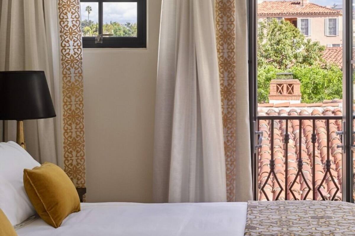 Une chambre d’hôtel avec un lit, une fenêtre et une vue sur l’extérieur.