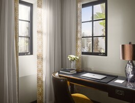 Un escritorio con una computadora portátil, libros y un florero.