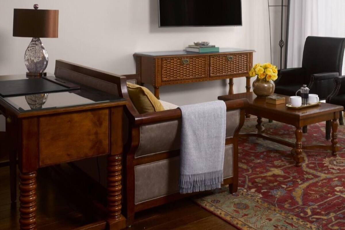 Un salon avec un canapé, une table basse, un téléviseur et une lampe.