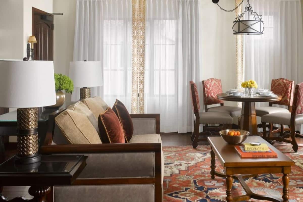 Un salon traditionnel avec un canapé, des fauteuils, une table basse et une table à manger.