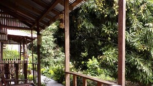 A wooden pergola with a stone pathway leading to a seating area. - Finca Santa Mónica (Xilitla)