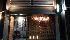Un bâtiment doté d’une grande entrée et d’un espace abrité agrémenté d’une clôture décorative.