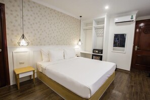 A bedroom with a bed, bedside tables, a wardrobe, an air conditioning unit, and a window with blinds. - Hanoi A83 Hotel (Hanoi)