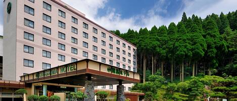 A hotel with a modern facade, multiple floors, and a covered entrance area.