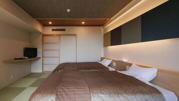 A hotel room with a bed, a television, a wardrobe, and a window.