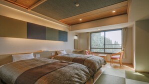 A hotel room with two beds, a desk, a chair, and a large window. - Kirishima Hotel (Kirishima)