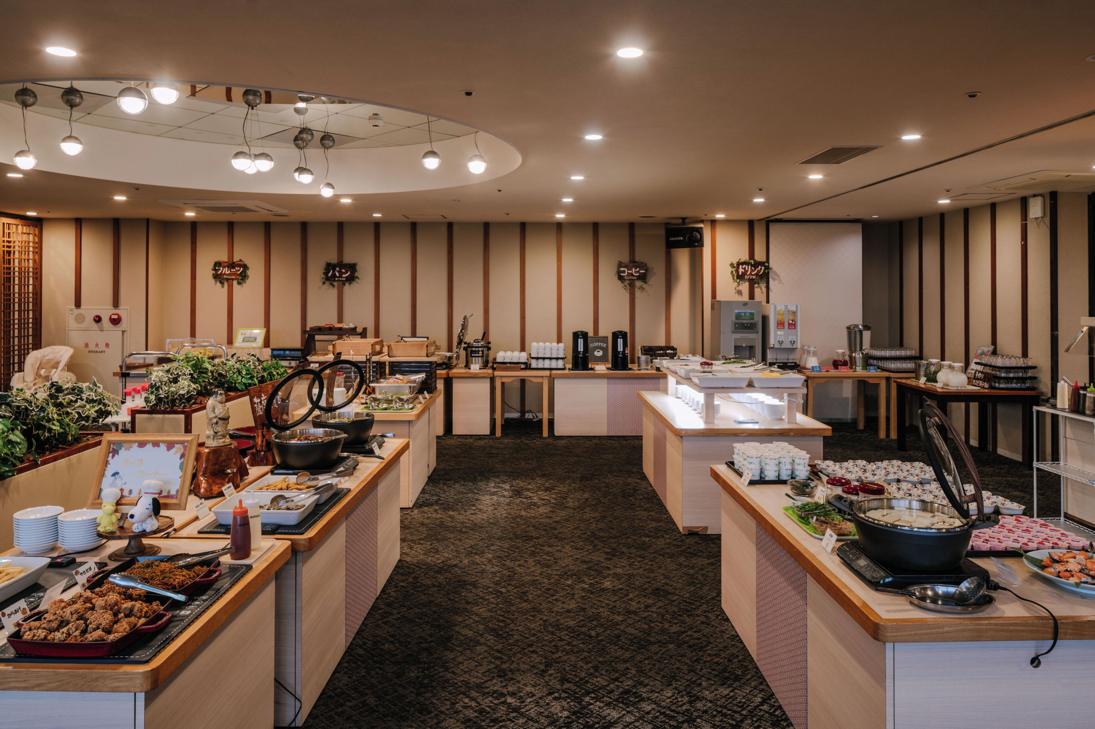 A buffet area with multiple serving stations, a reception desk, and a wall-mounted clock.
