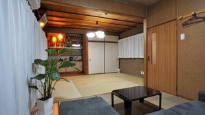 Une pièce de style japonais traditionnel, avec un sol recouvert de tatamis, une table basse et un canapé.