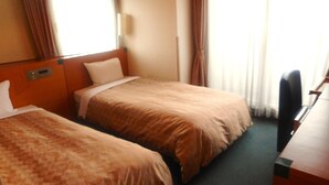 Una habitación de hotel con dos camas, un escritorio y una silla.