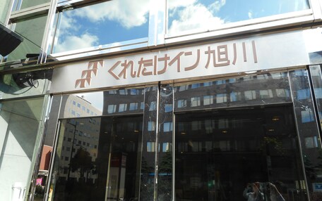 A building with large glass windows and a sign with Japanese characters.