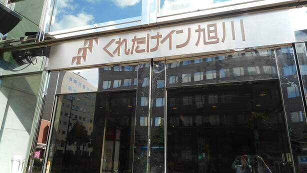 Un edificio con amplios ventanales y un letrero con caracteres japoneses.