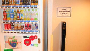 A vending machine with various beverages and snacks, a 'Best Selection' sign, and a VOD card machine.