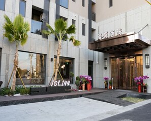 A hotel entrance with a sign reading "JOY INN" and a modern building facade. - Joy Inn (Lukang)