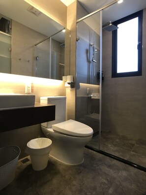 A modern bathroom with a glass-enclosed shower, a toilet, and a sink. - Joy Inn (Lukang)