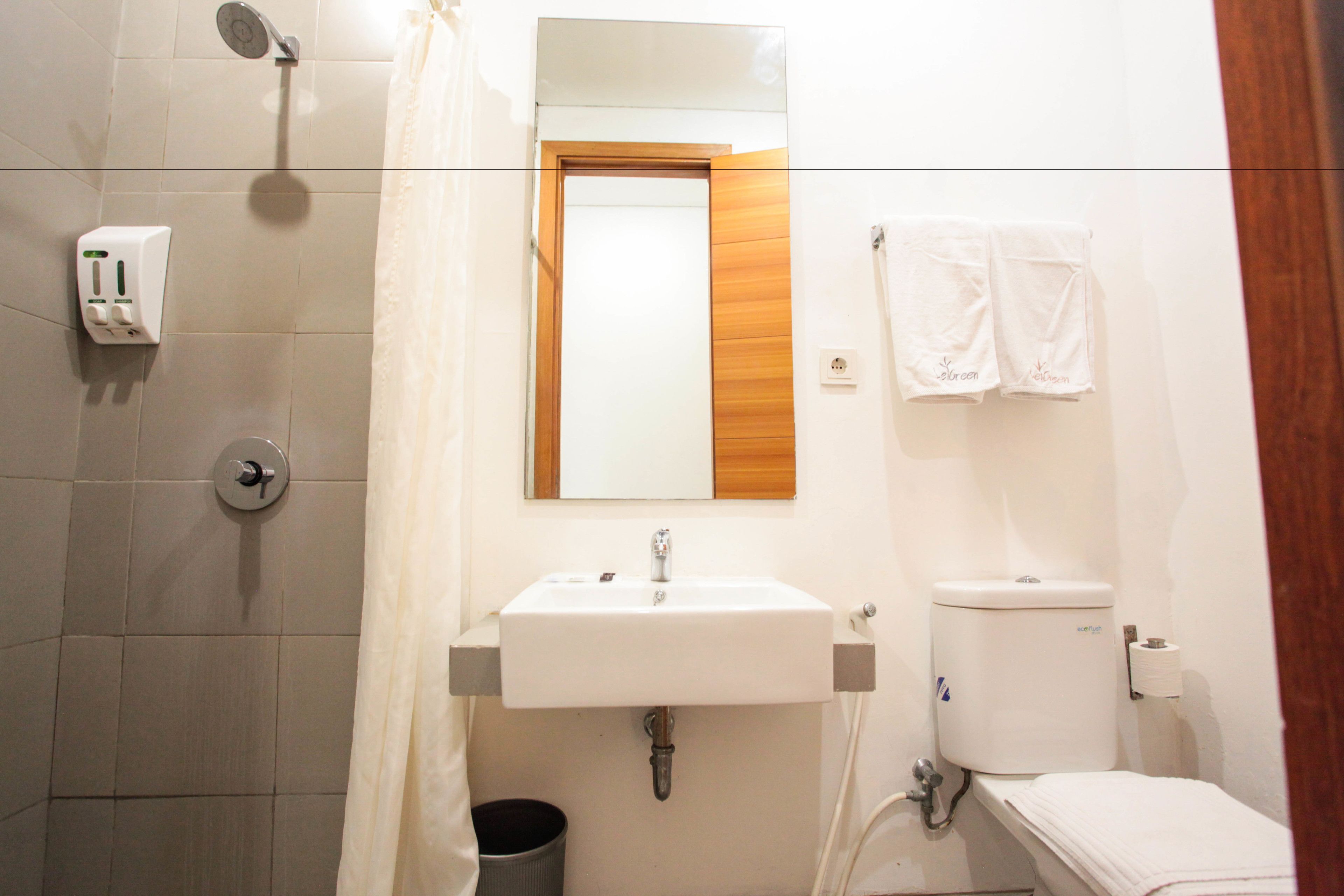 Un baño con lavabo, espejo, ducha e inodoro.
