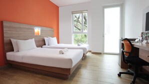 A hotel room with two beds, a desk, and a chair. - LeGreen Suite Kuningan (Jakarta)