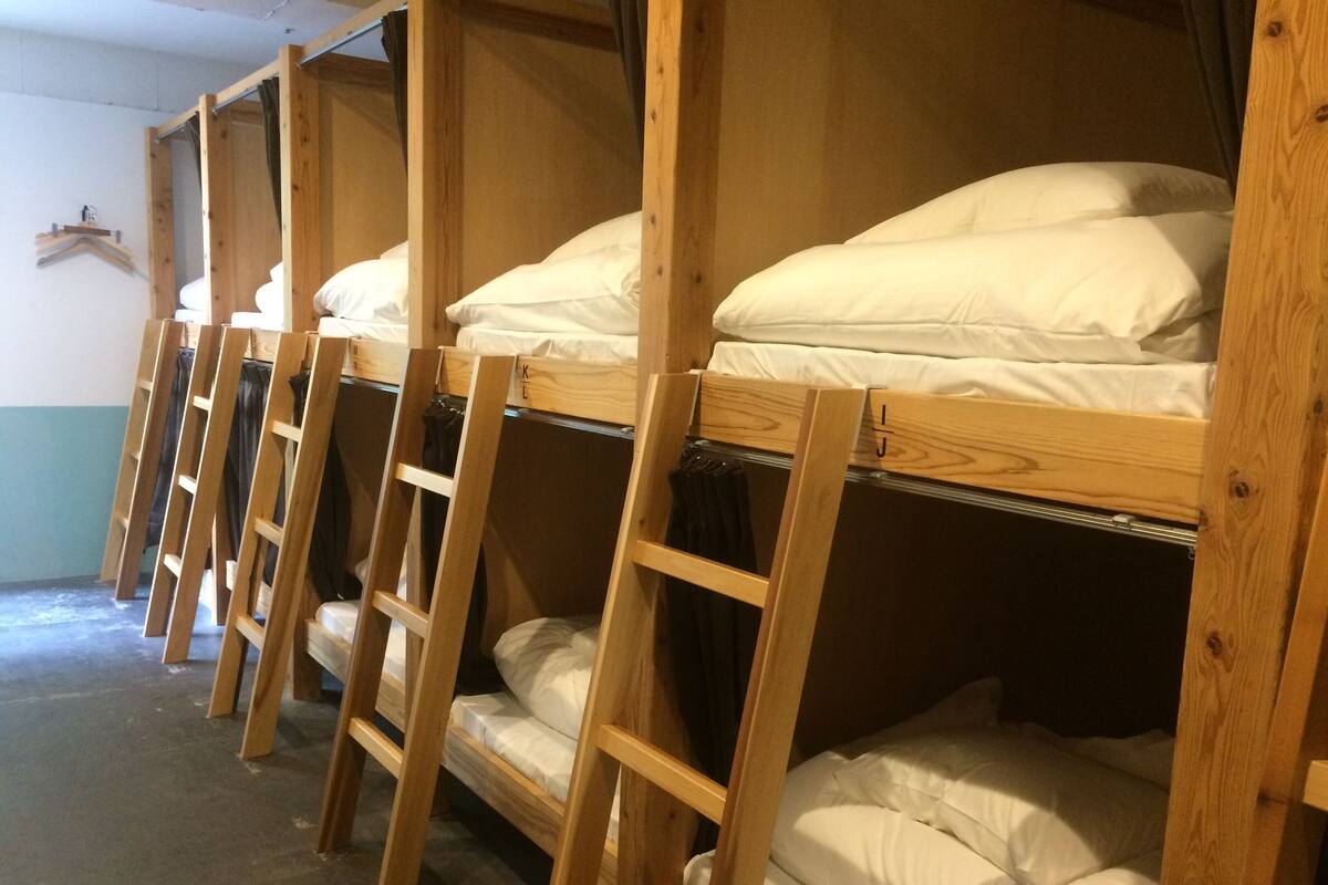 Bunk beds with wooden frames and white bedding.