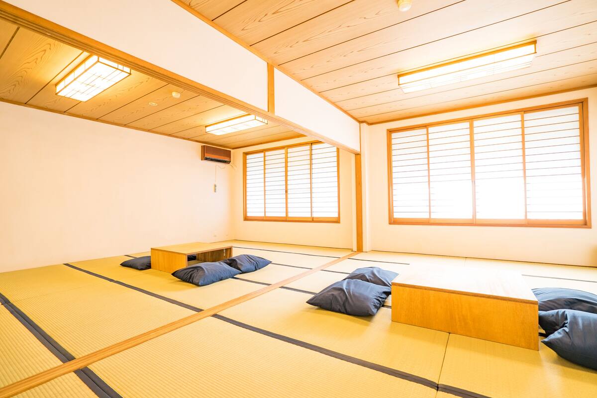 Habitació amb esteres de tatami, bigues de fusta i una plataforma de fusta baixa.
