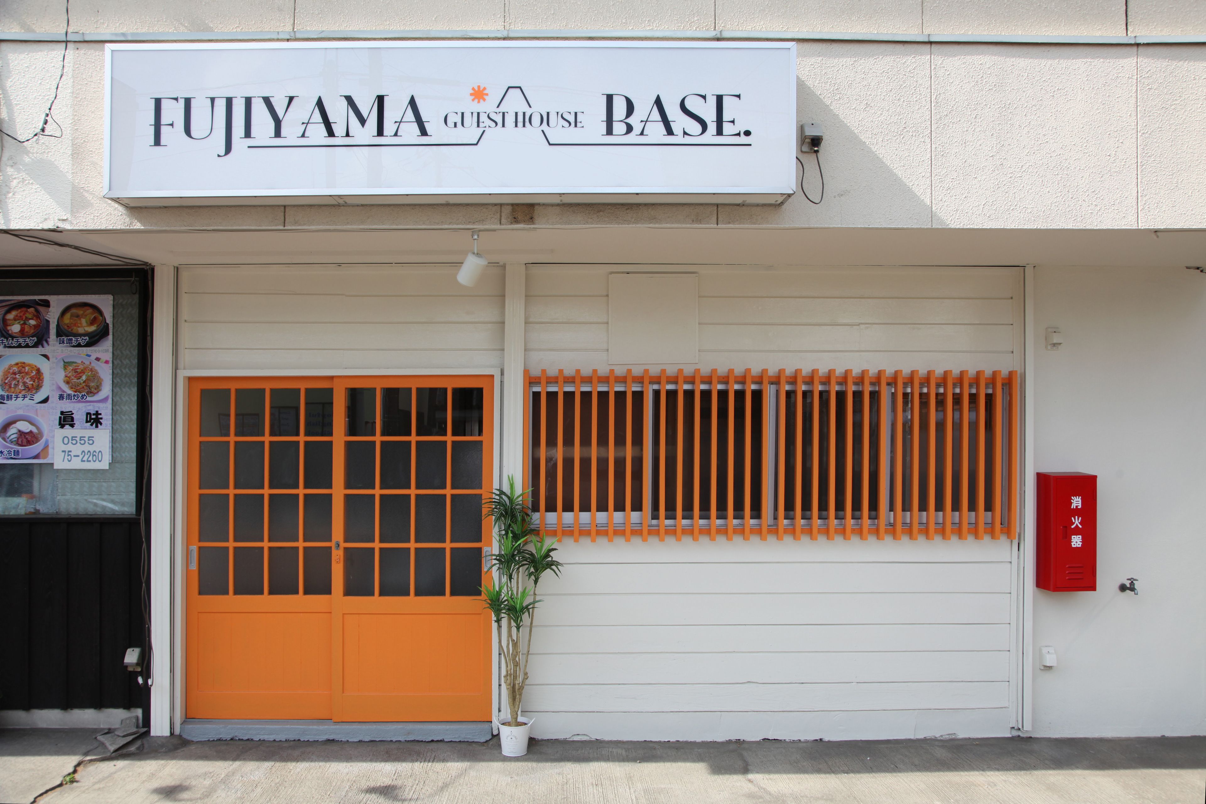 A building with a sign reading "FUJIYAMA GUESTHOUSE BASE."