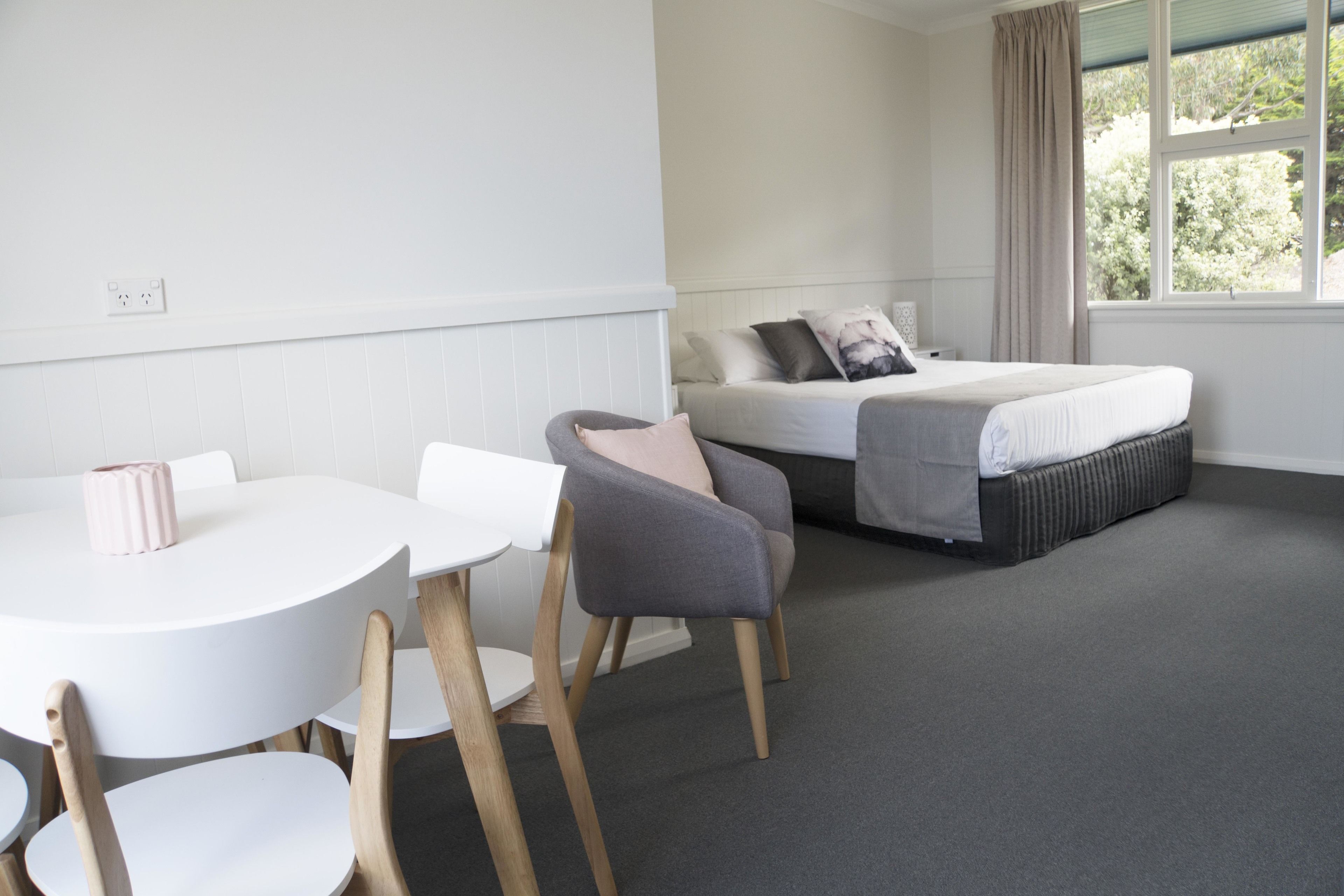Ein Hotelzimmer mit einem Bett, einem kleinen Tisch und zwei Stühlen.