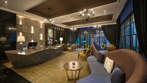 Un moderno vestíbulo de hotel con mostrador de recepción, zona de estar y grandes ventanales con vistas.