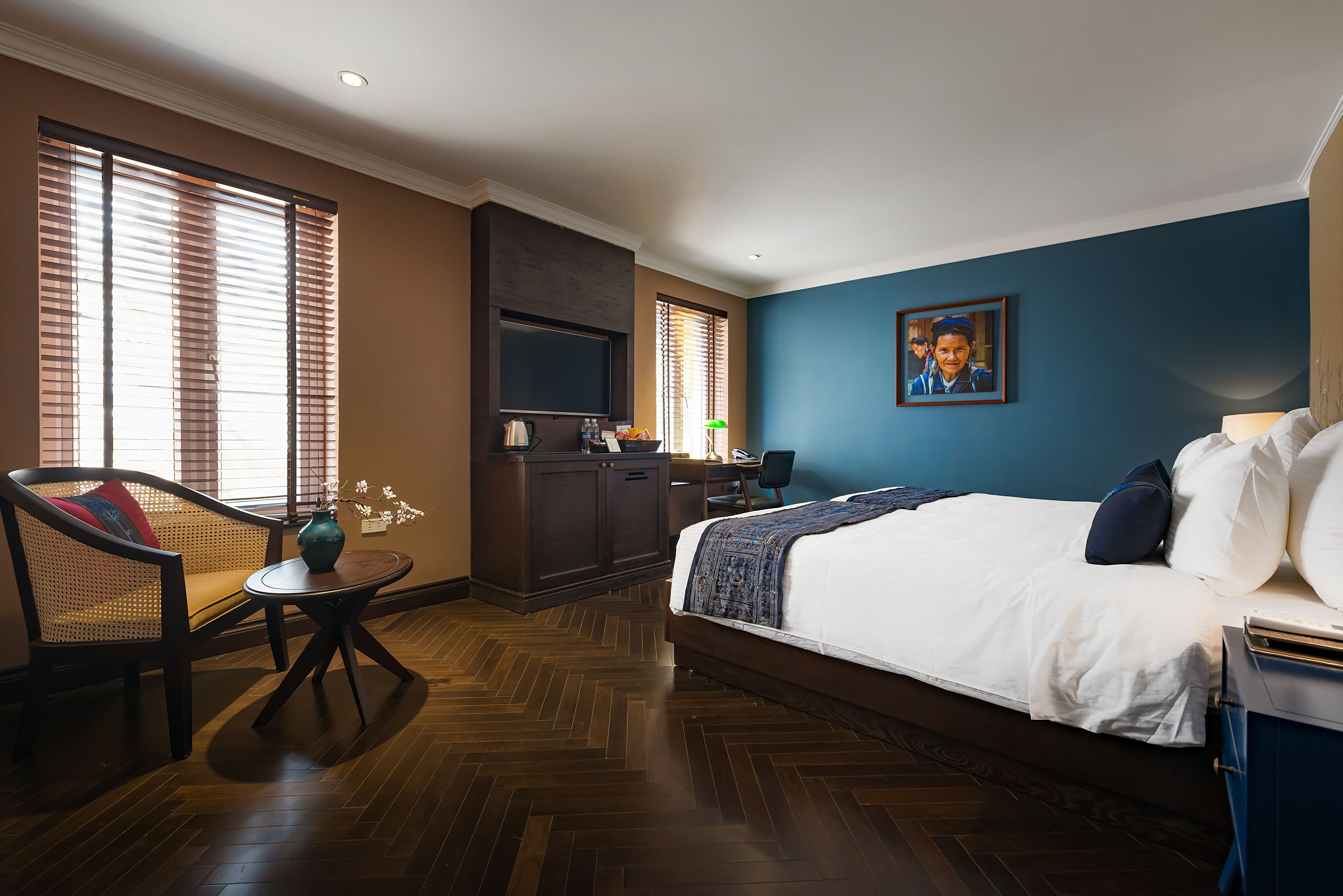 Een hotelkamer met een bed, een bureau, een stoel en een televisie.