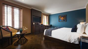 Een hotelkamer met een bed, een bureau, een stoel en een televisie.