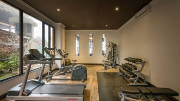 A gym with treadmills, elliptical machines, and weight benches.