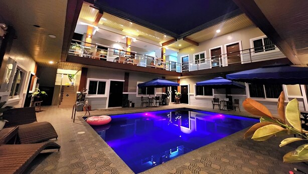 Une piscine intérieure avec un éclairage bleu, un balcon avec des sièges et un intérieur bien éclairé.