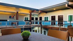 Une terrasse sur le toit avec des espaces de détente en plein air, une piscine et plusieurs portes donnant accès aux chambres.