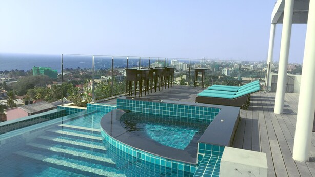 Una piscina infinita en la azotea con vistas a la ciudad y al océano.