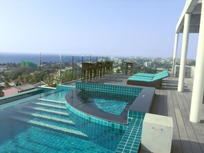 Una piscina infinita en la azotea con vistas a la ciudad y al océano.