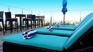 Un área de lounge en la azotea con dos sillones reclinables, una mesa y sillas.