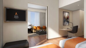Una habitación de hotel moderna con una cama, un escritorio, una silla, un televisor y un cuadro.
